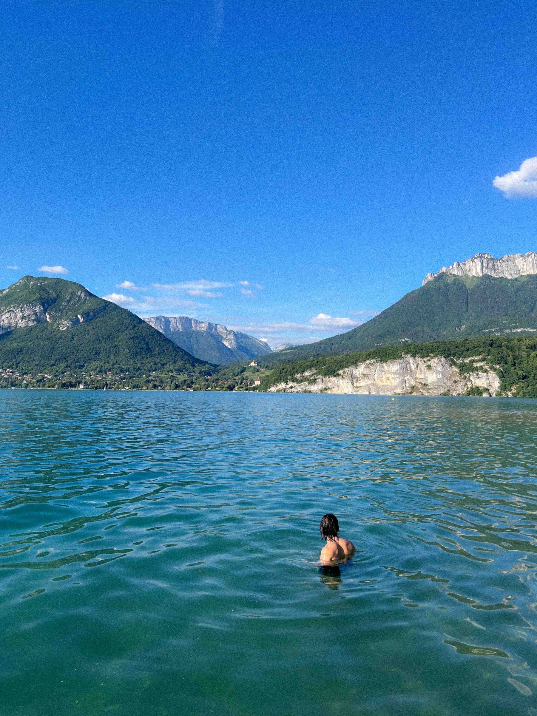 A swimmer heading into a mountain lake